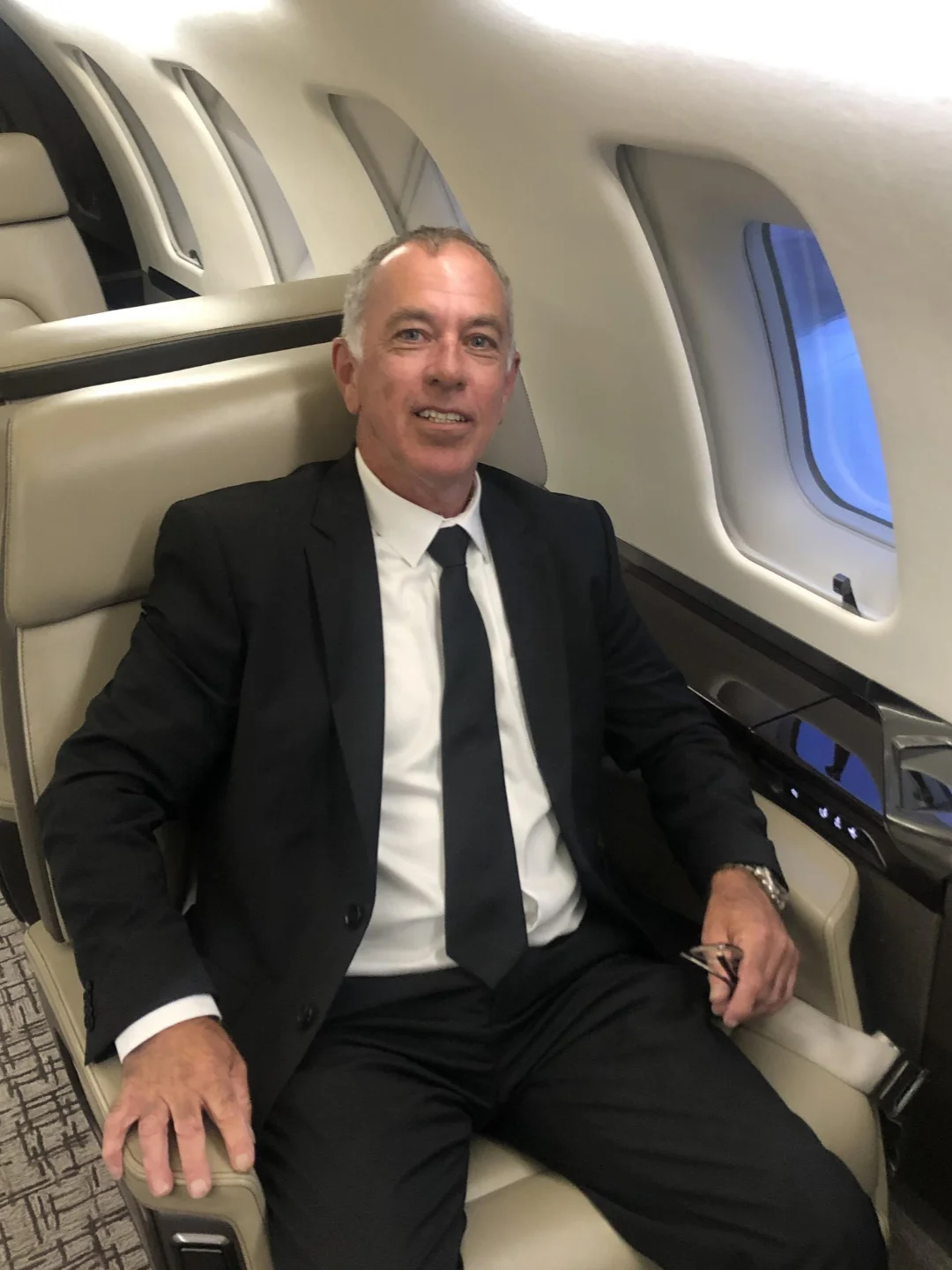John Coady Owner of Code E Cars Chauffeur Service in a suit sat on a client's private jet