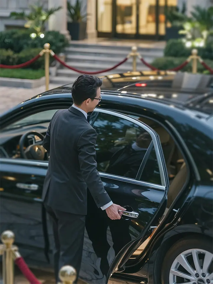 Luxury Chauffeur Service opening rear door of Mercedes S-Class LWB for client